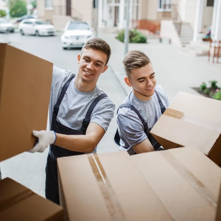 Zwei Umzugshelfer arbeiten für ein Umzugsunternehmen in Hamburg und tragen Kartons