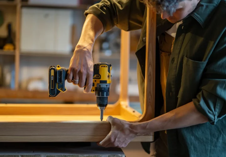 Mitarbeiter_bei_der_Möbelmontage_in_Quickborn Mitarbeiter montiert Möbel mit Akkuschrauber während des Umzugs in Quickborn