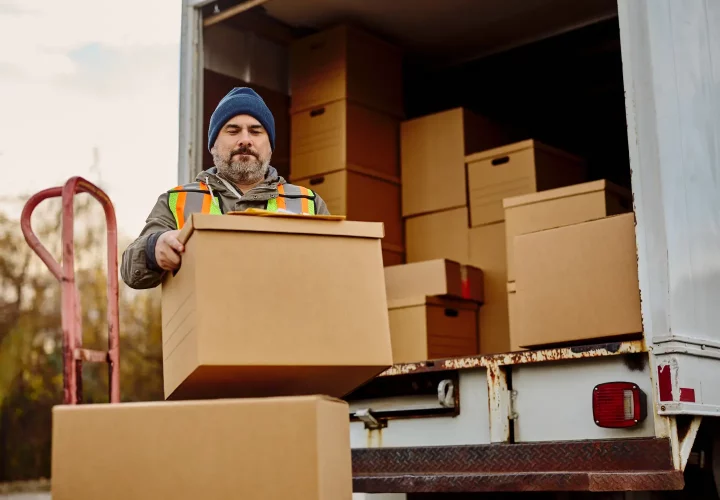 Möbelpacker_ladet_Umzugkartons_aus_für_einen_Umzug_in_Quickborn (1) Möbelpacker entlädt Umzugskartons aus LKW für den Umzug in Quickborn